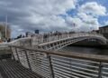 Ha'penny Bridge, Dublino. Il celebre Ha'penny Bridge attraversa il fiume Liffey in una rara giornata di sole nel cuore di Dublino. Simbolo storico della capitale irlandese, il ponte rappresenta ancora oggi uno dei luoghi più iconici della città, meta quotidiana di residenti, lavoratori e turisti.