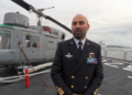 Alessandro De Lucia, comandante di Nave Etna, sul ponte di volo dell’unità della Marina Militare Italiana, con alle spalle l’elicottero di bordo.
