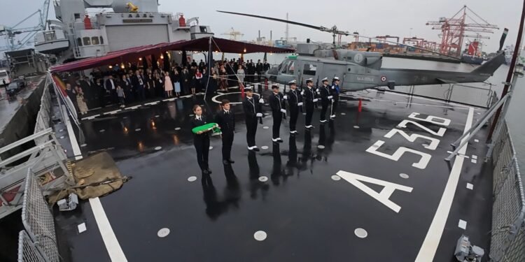 Sul ponte di volo di ITS ETNA, i militari della Marina Militare Italiana schierati con il Tricolore solennemente ripiegato al termine dell’Ammaina Bandiera. A destra l’elicottero di bordo, mentre sullo sfondo gli ospiti – rappresentanti istituzionali, diplomatici, esponenti del mondo politico e imprenditoriale e membri della comunità – osservano con attenzione uno dei momenti più suggestivi della serata a Dublin Port.
